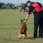 A police officer in a uniform pets a german shepherd at the uspca national patrol dog trial 2023 in foley, alabama.