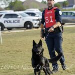 A police officer with a canine running at a uspca national patrol dog trial event in foley, alabama, 2023.